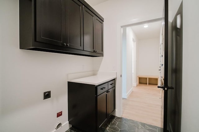 laundry room with hookup for an electric dryer and cabinets