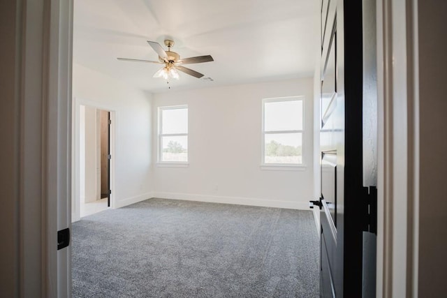 carpeted spare room with ceiling fan