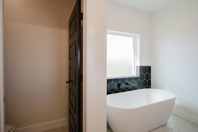 bathroom with a bath, toilet, and tasteful backsplash