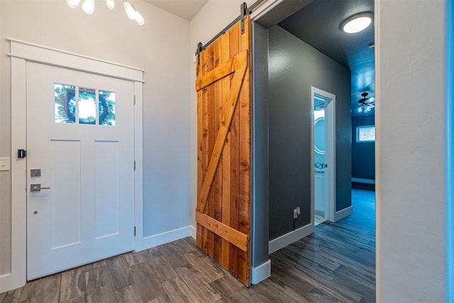 foyer with dark wood-type flooring and a barn door