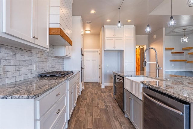 kitchen with light stone counters, stainless steel appliances, white cabinets, and hanging light fixtures