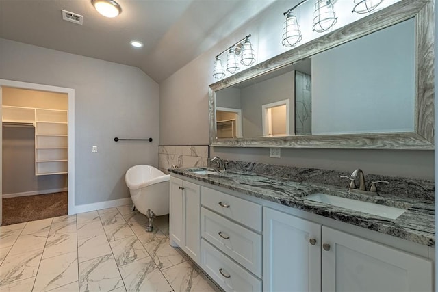 bathroom with a tub to relax in, vanity, and lofted ceiling