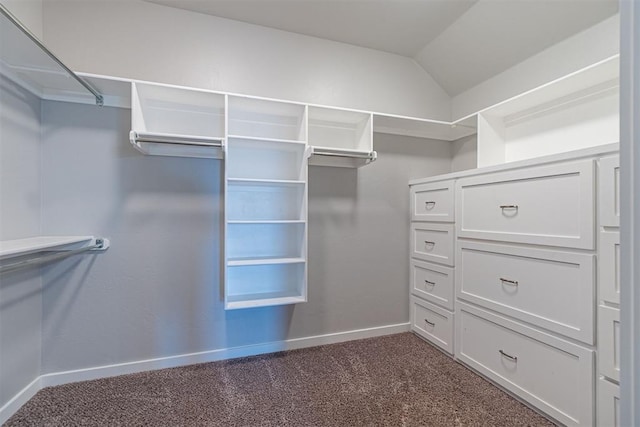 walk in closet with dark carpet and vaulted ceiling