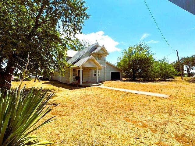 view of side of property featuring a garage and a lawn