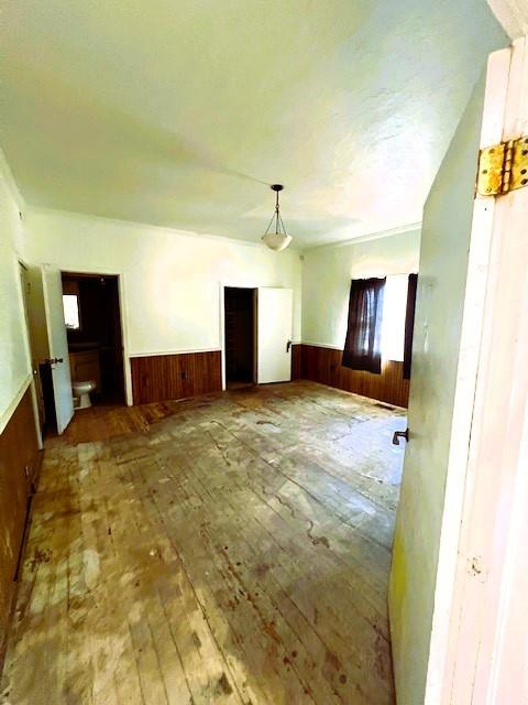 spare room featuring hardwood / wood-style flooring and wooden walls