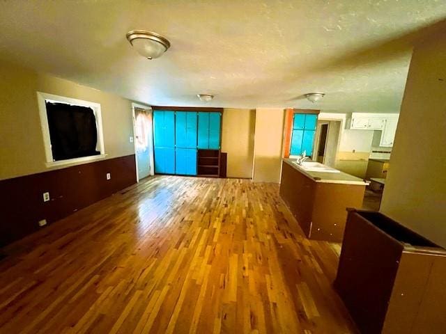 unfurnished living room with hardwood / wood-style floors and sink