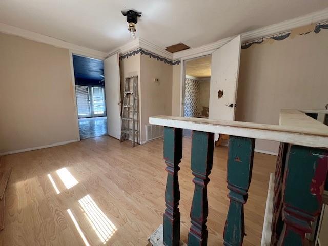 interior space with ornamental molding and hardwood / wood-style floors