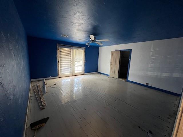 empty room with ceiling fan and wood-type flooring