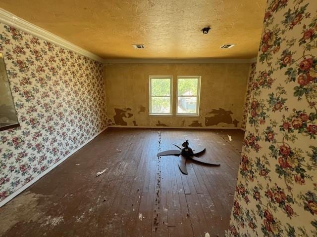 miscellaneous room featuring wood-type flooring, crown molding, and a textured ceiling