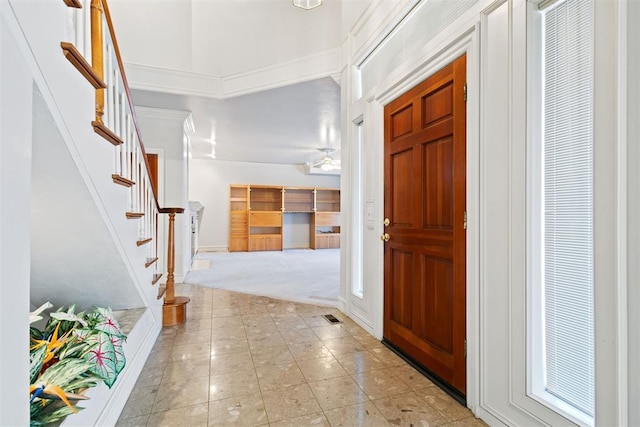 carpeted entrance foyer featuring a high ceiling