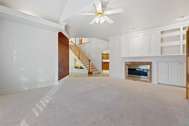 unfurnished living room featuring ceiling fan, lofted ceiling, light carpet, and a brick fireplace