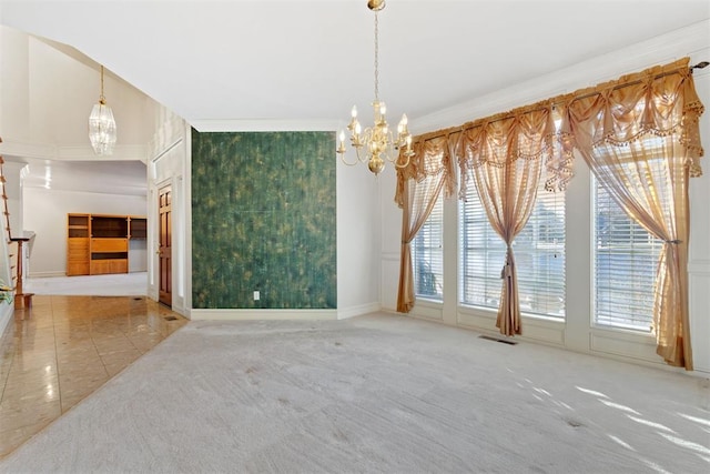 carpeted empty room featuring crown molding and a chandelier