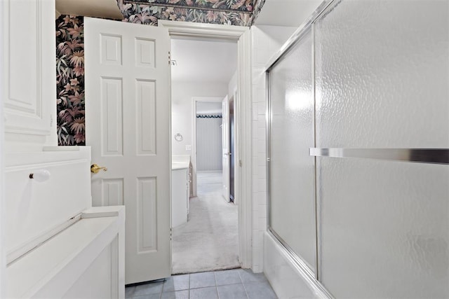 bathroom featuring tile patterned flooring, vanity, and enclosed tub / shower combo