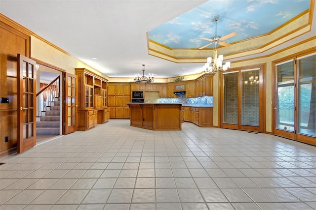 kitchen featuring ventilation hood, a center island, hanging light fixtures, and a raised ceiling