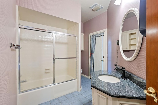 full bathroom with tile patterned flooring, vanity, combined bath / shower with glass door, and toilet