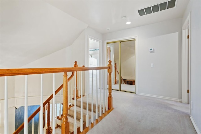 corridor featuring light colored carpet