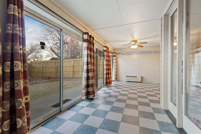 unfurnished sunroom with radiator heating unit and ceiling fan