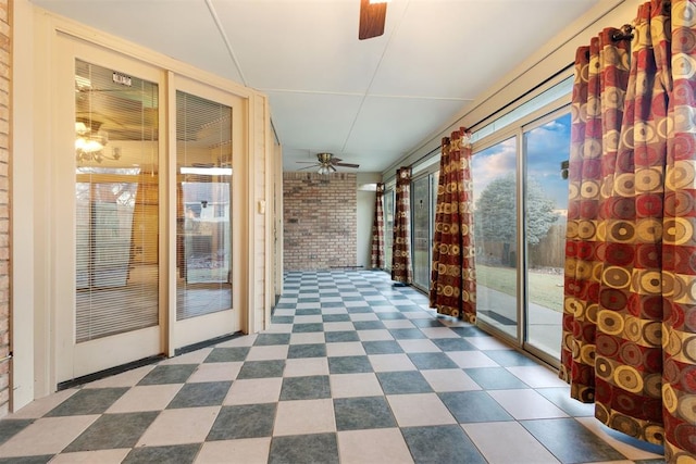 unfurnished sunroom with ceiling fan