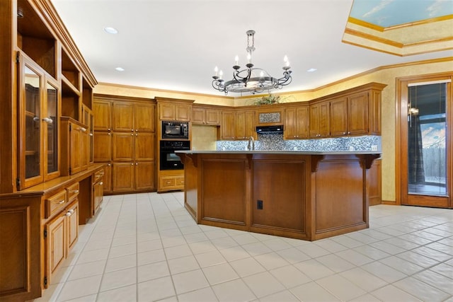 kitchen with a kitchen island, decorative light fixtures, a kitchen bar, and black appliances