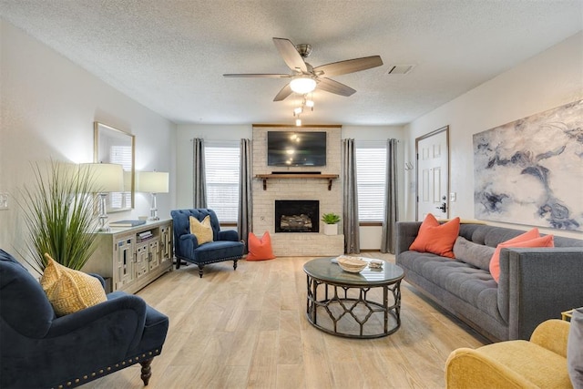 living room featuring plenty of natural light, a textured ceiling, and light hardwood / wood-style flooring