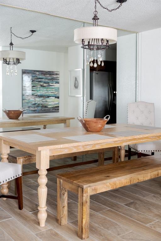 unfurnished dining area with a textured ceiling and a notable chandelier