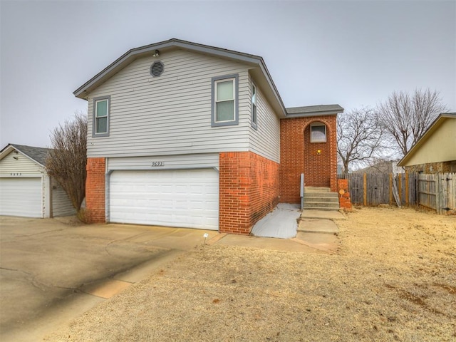 view of front facade featuring brick siding, driveway, a garage, and fence