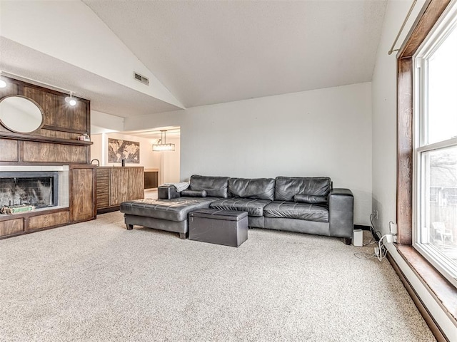 carpeted living area with a tiled fireplace, visible vents, and high vaulted ceiling