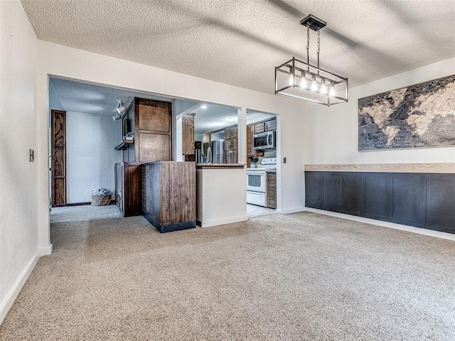 interior space featuring white electric range, stainless steel microwave, a textured ceiling, carpet, and baseboards