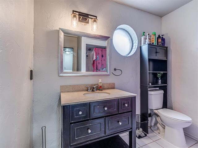 full bath with toilet, vanity, and a textured wall