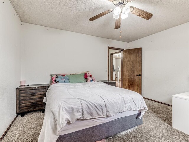 carpeted bedroom with a ceiling fan, baseboards, and a textured ceiling