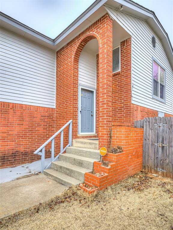 entrance to property with brick siding and fence