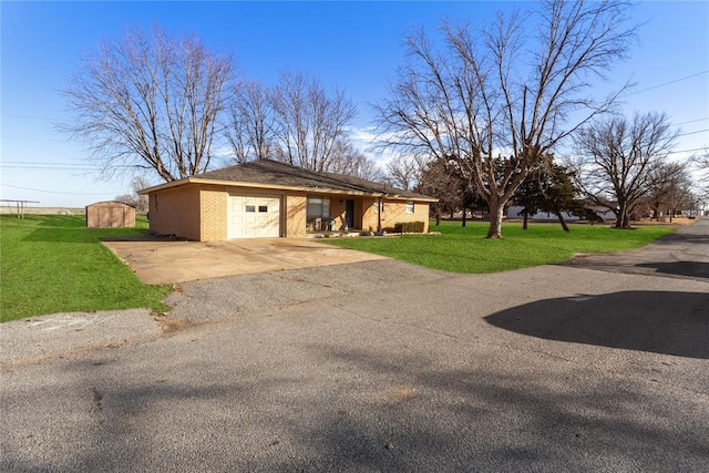 view of front of home with a garage, a front yard, and a storage shed