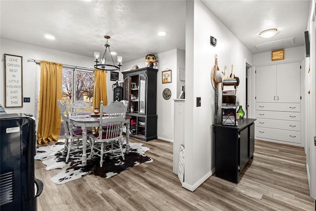 dining room featuring wood-type flooring and an inviting chandelier