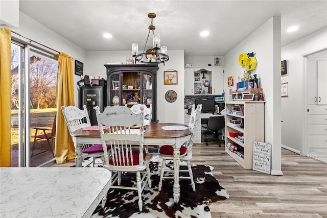 dining space with a notable chandelier and light hardwood / wood-style flooring