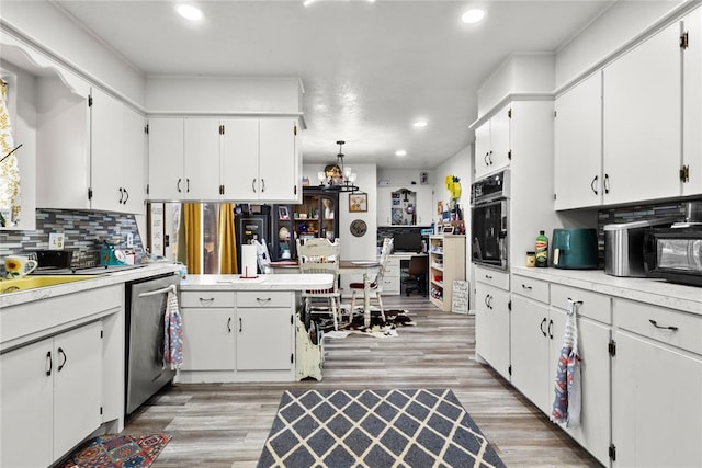 kitchen with dishwasher, white cabinets, and black oven