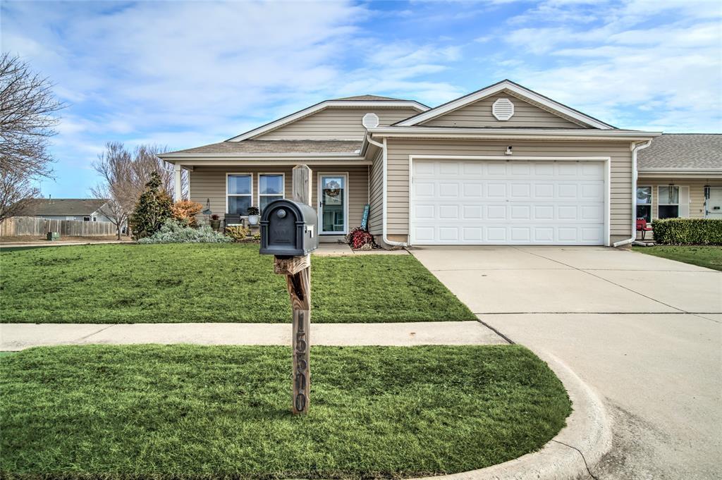 single story home with a garage and a front lawn