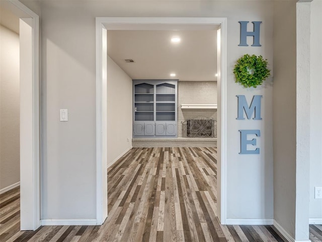 hallway featuring wood-type flooring and built in features