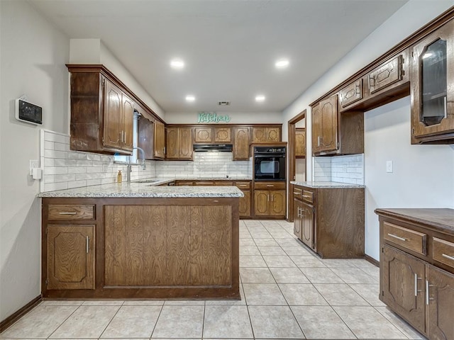 kitchen featuring light stone countertops, sink, kitchen peninsula, oven, and light tile patterned floors