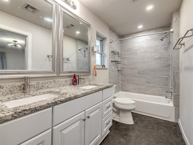 full bathroom with toilet, tiled shower / bath combo, tile patterned floors, and vanity