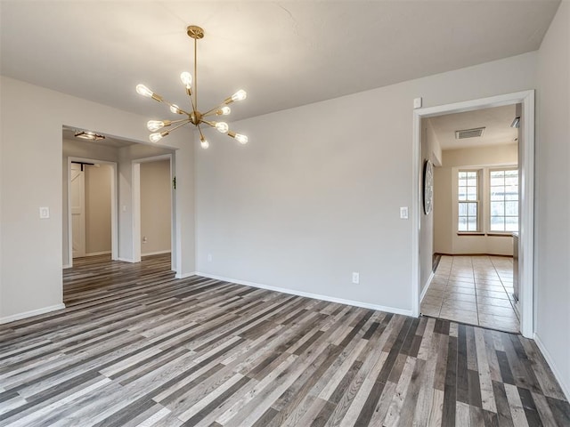 unfurnished room with hardwood / wood-style floors and a chandelier