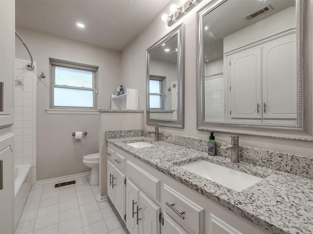 full bathroom featuring tile patterned floors, vanity, toilet, and tiled shower / bath combo