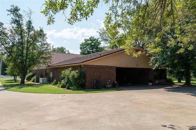 view of side of property with central AC unit, a garage, and a yard