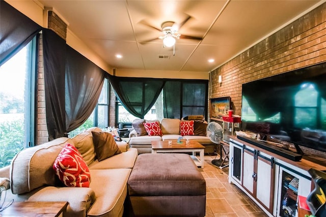 living room with ceiling fan and brick wall