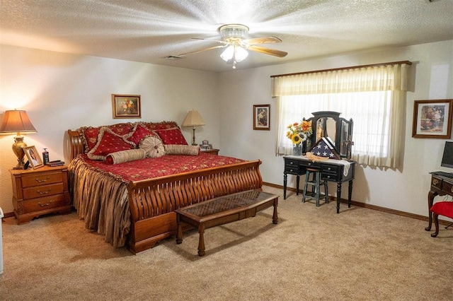 bedroom featuring ceiling fan, a textured ceiling, and light carpet