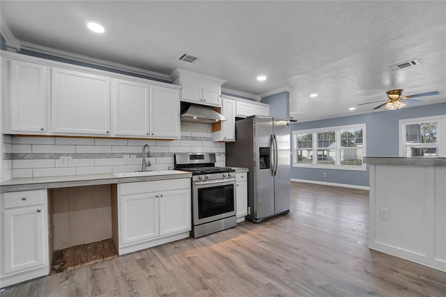 kitchen with sink, white cabinetry, appliances with stainless steel finishes, and crown molding