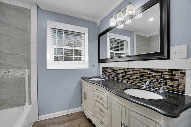 bathroom featuring hardwood / wood-style flooring, ornamental molding, tasteful backsplash, and vanity