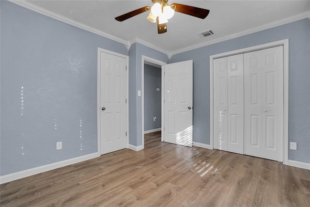 unfurnished bedroom featuring ceiling fan, light wood-type flooring, a closet, and crown molding