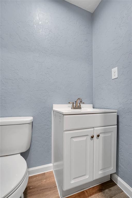 bathroom featuring toilet, hardwood / wood-style flooring, and vanity