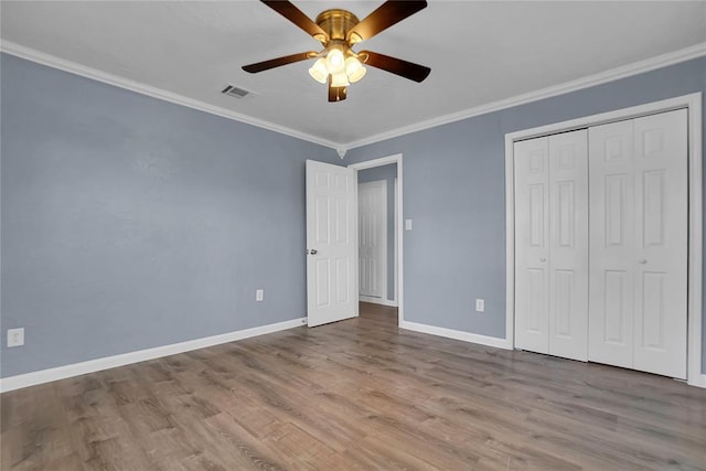 unfurnished bedroom with ceiling fan, a closet, ornamental molding, and light hardwood / wood-style flooring