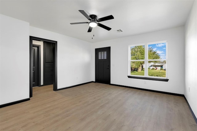 empty room with ceiling fan and light hardwood / wood-style flooring